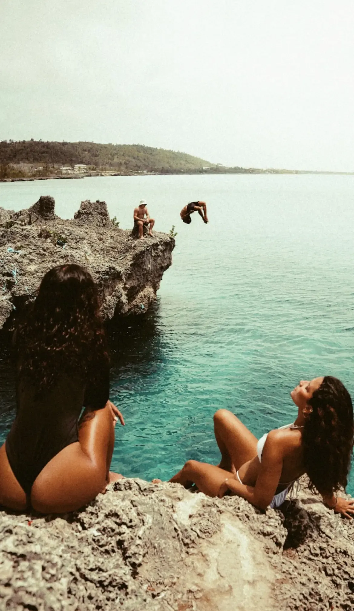 Cliff jumping into turquoise water in San Andrés